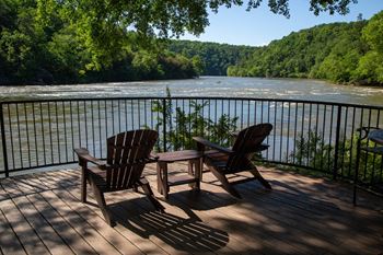 two chairs on a deck overlooking the river